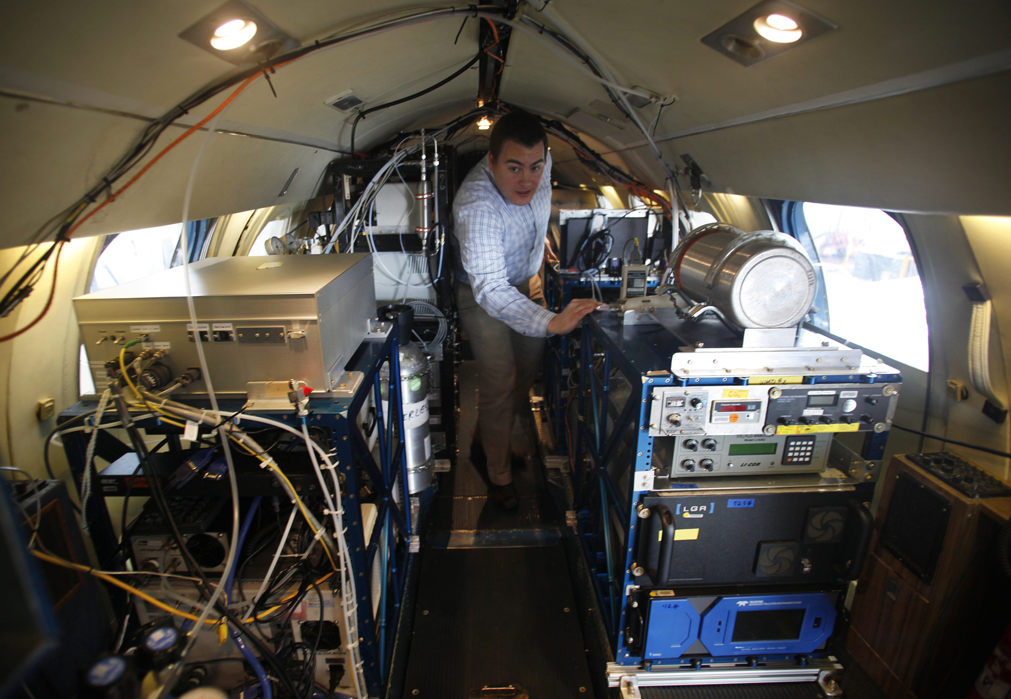 Dr. Rich Moore walks down the aisle of a research plane filled with scientific instruments.