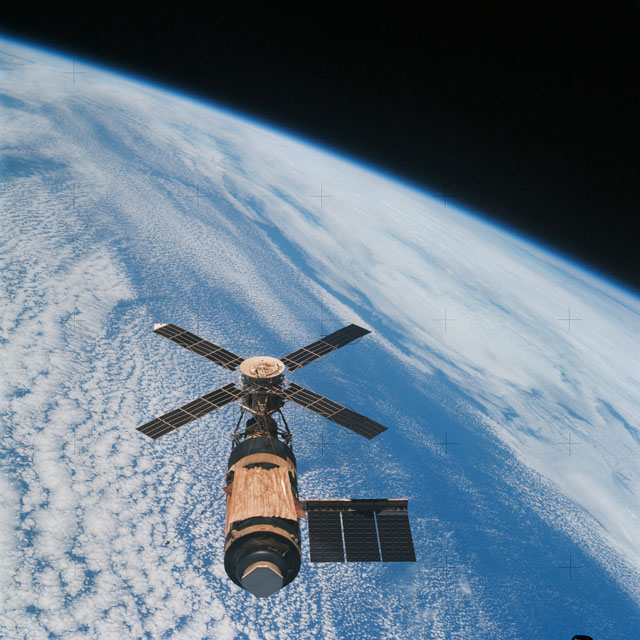 Skylab in space, above a blue-hued Earth