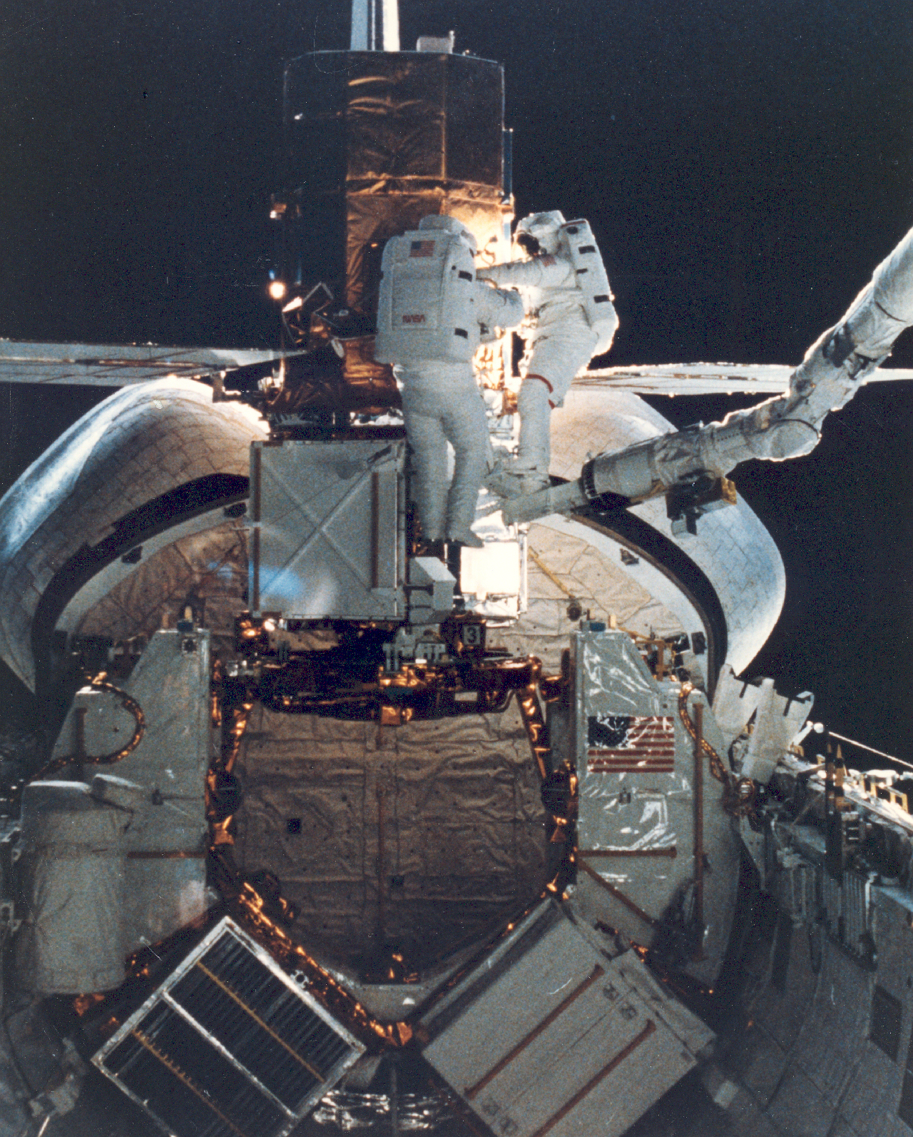 Astronauts work with SolarMax satellite in space shuttle cargo bay