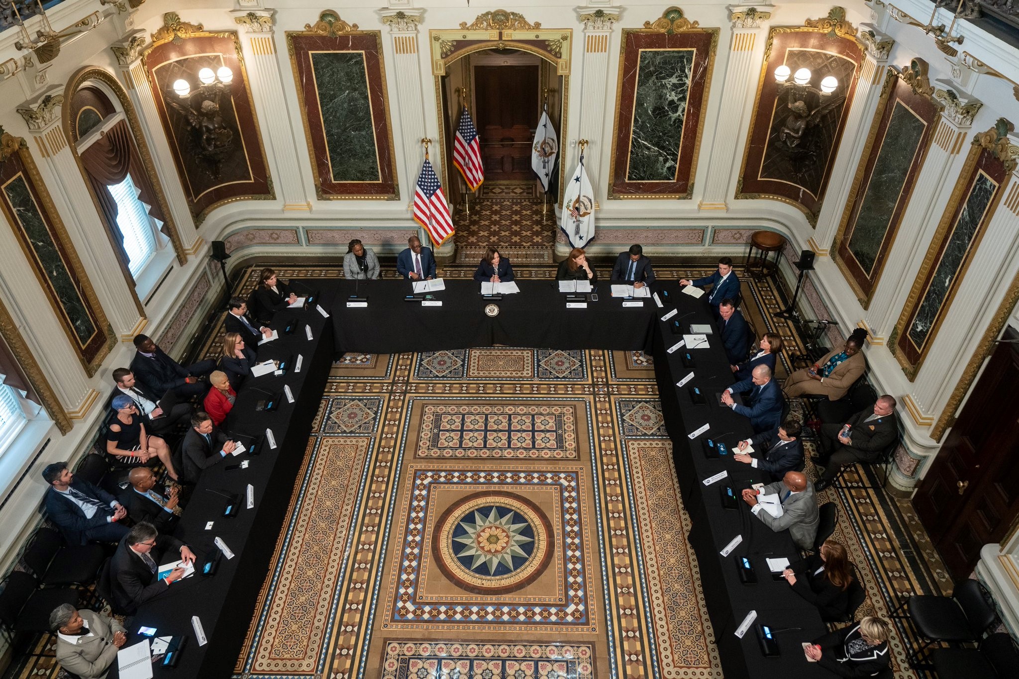 Image taken from a top down perspective of a U-shaped table at the White House with members of the Users' Advisory Group seated at it.