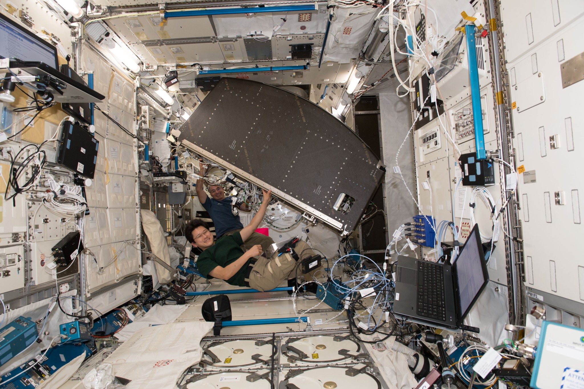 Flight Engineers Norishige Kanai and Mark Vande Hei working to relocate ExPRESS Rack 4 during Expedition 54. 