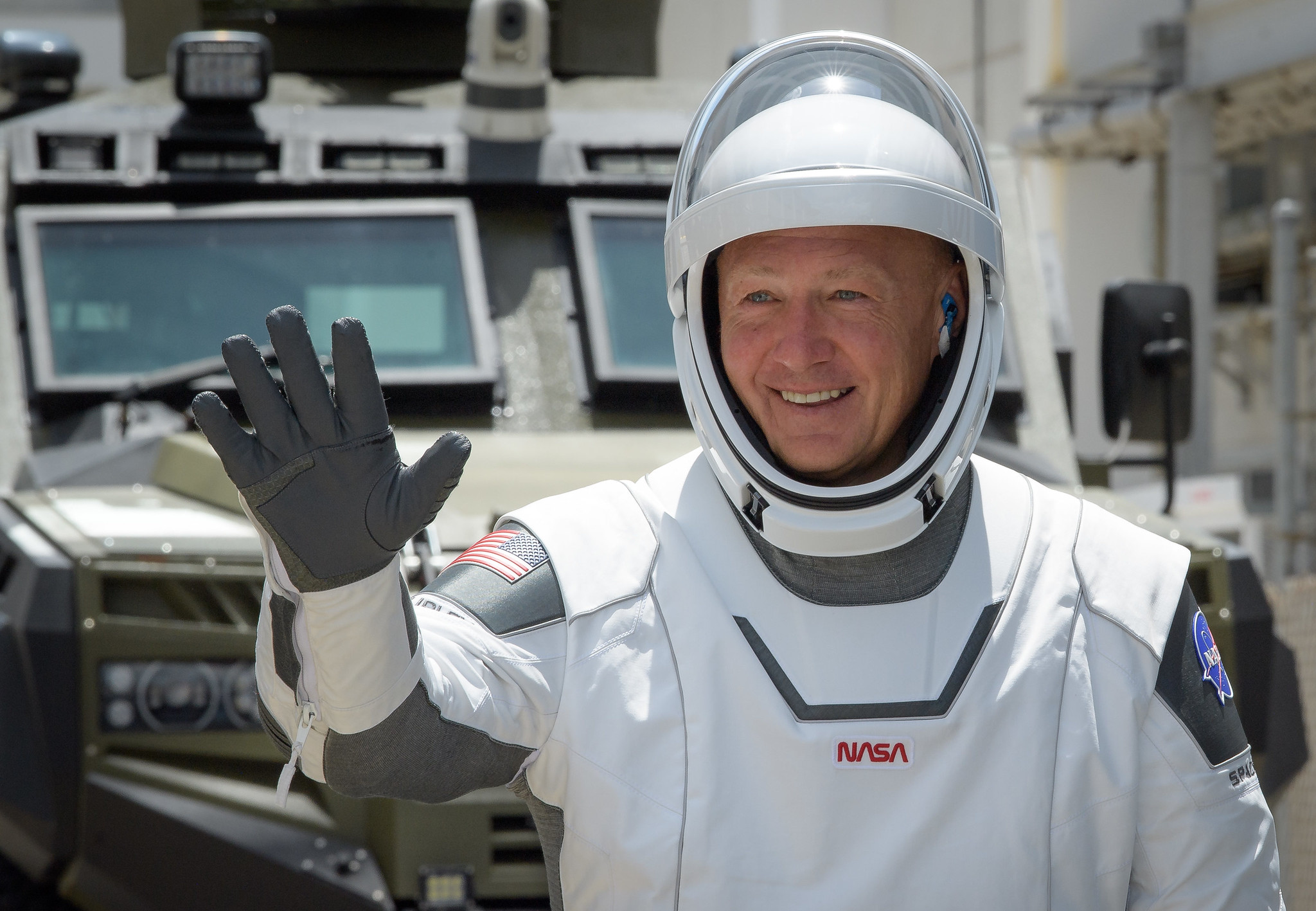 NASA astronaut Douglas Hurley waves as he departs the Neil A. Armstrong Operations and Checkout Building for Launch Complex 39A