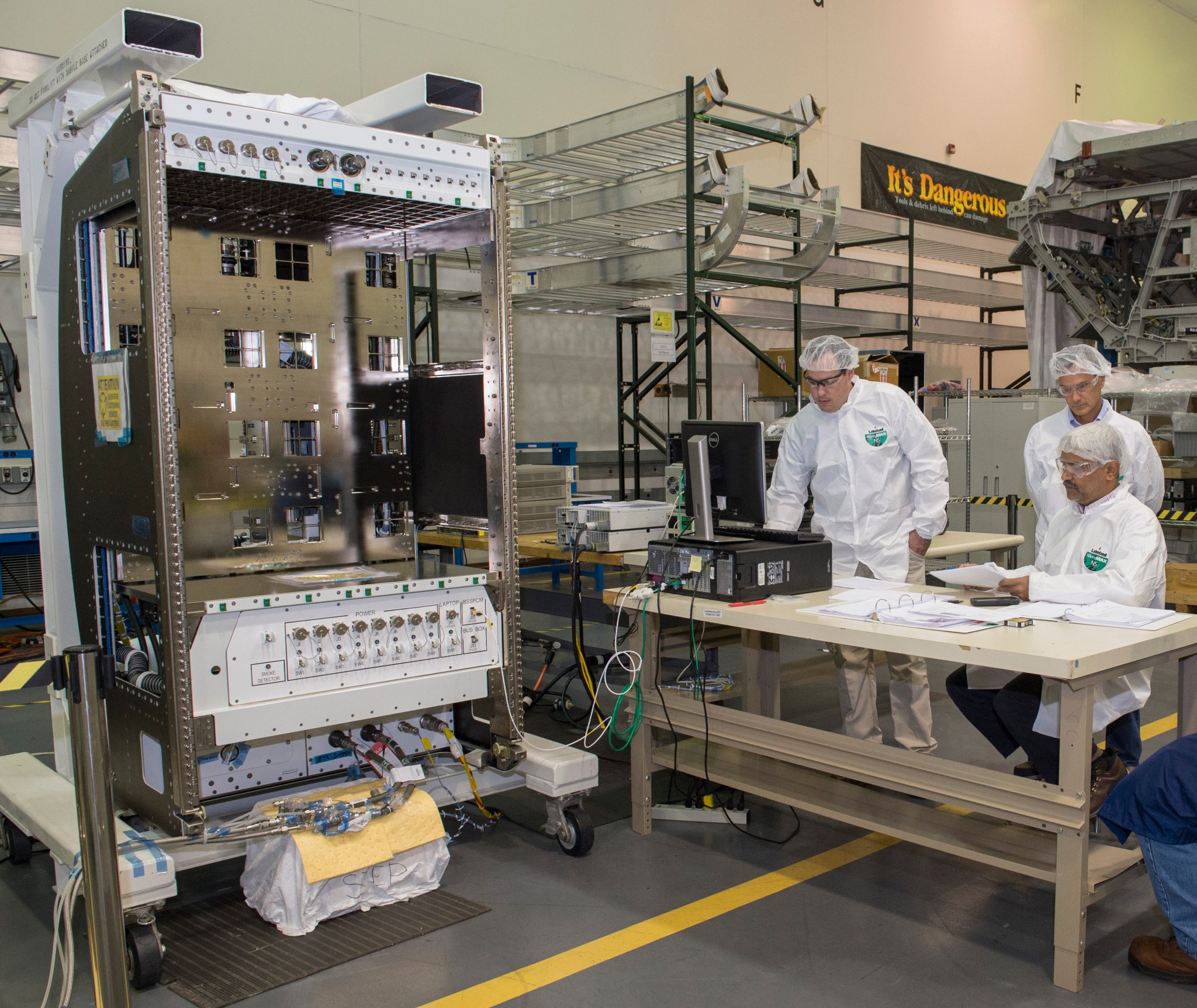 Chris Chapman, left, Greg Clark, center, and Ashesh Patel, right, perform air flow balance testing on new Basic Express Racks. 