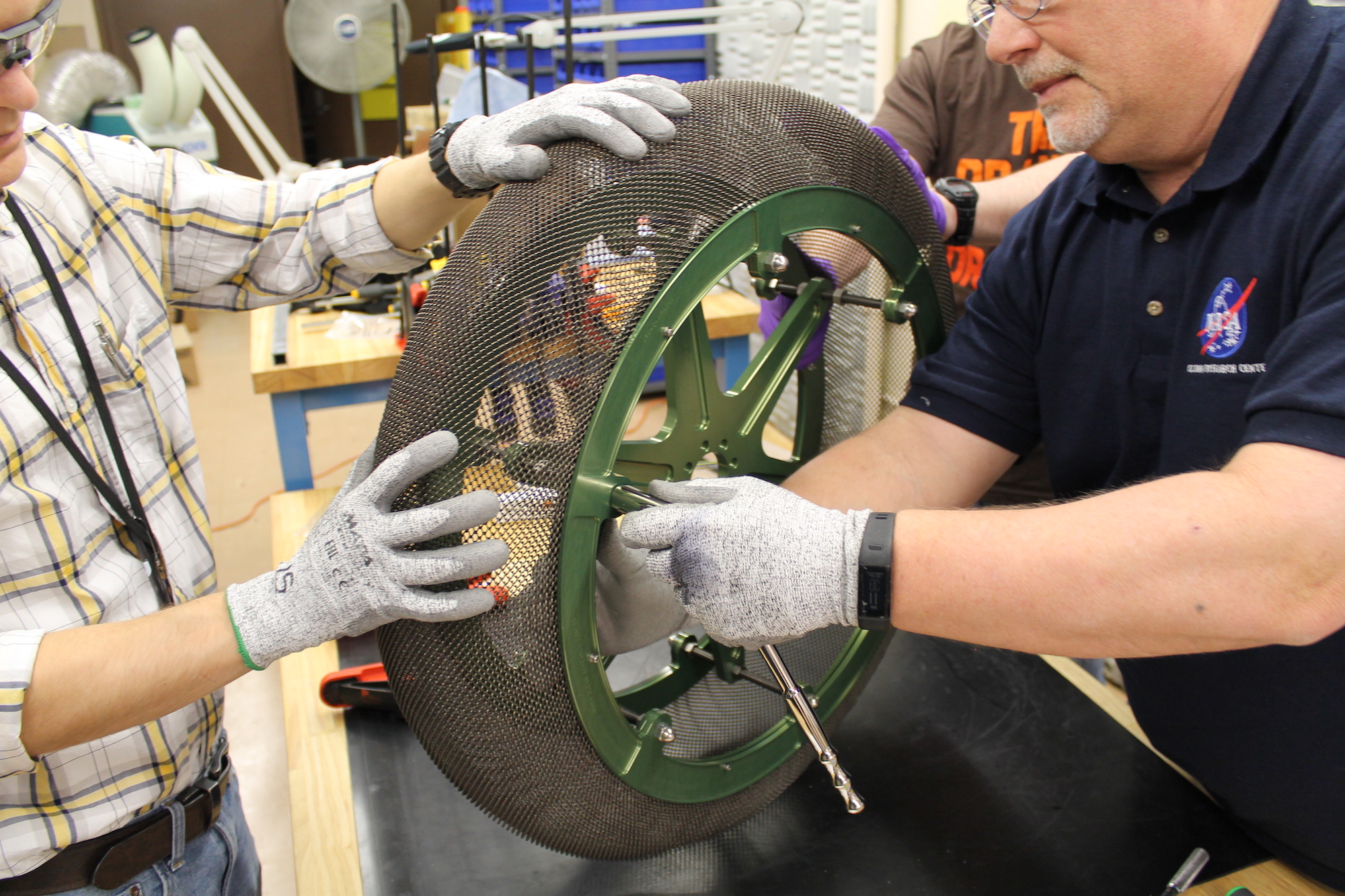 Two engineers working together to assemble a new rover tire.