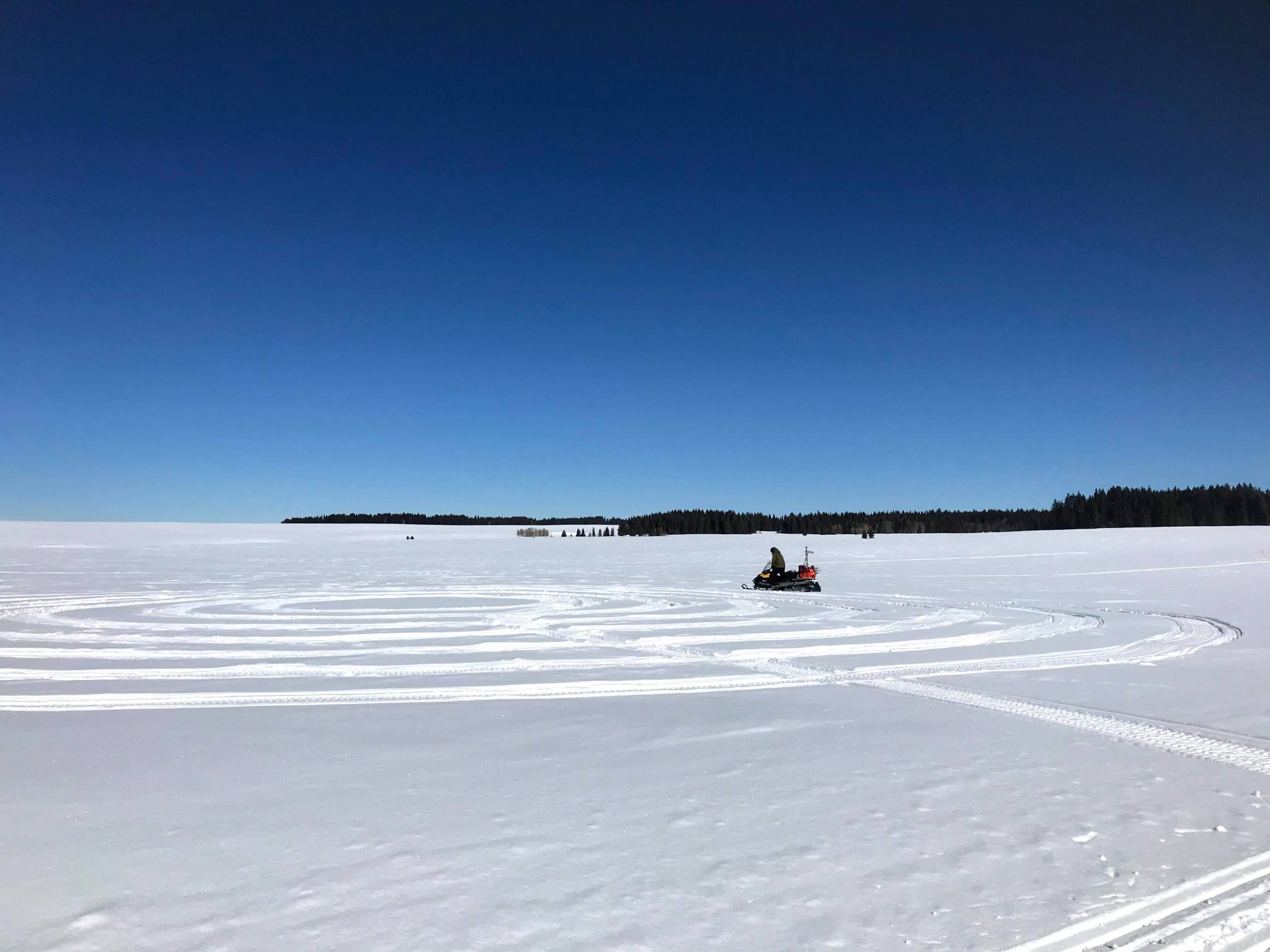 SnowEx scientist drives his snowmobile in a spiral