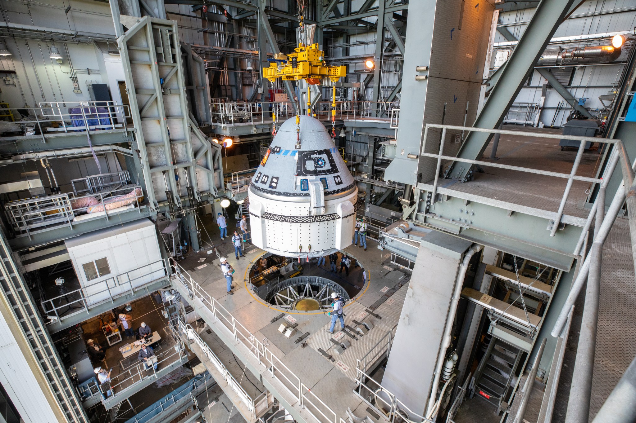 The Boeing CST-100 Starliner spacecraft is guided into position above a United Launch Alliance Atlas V rocket.