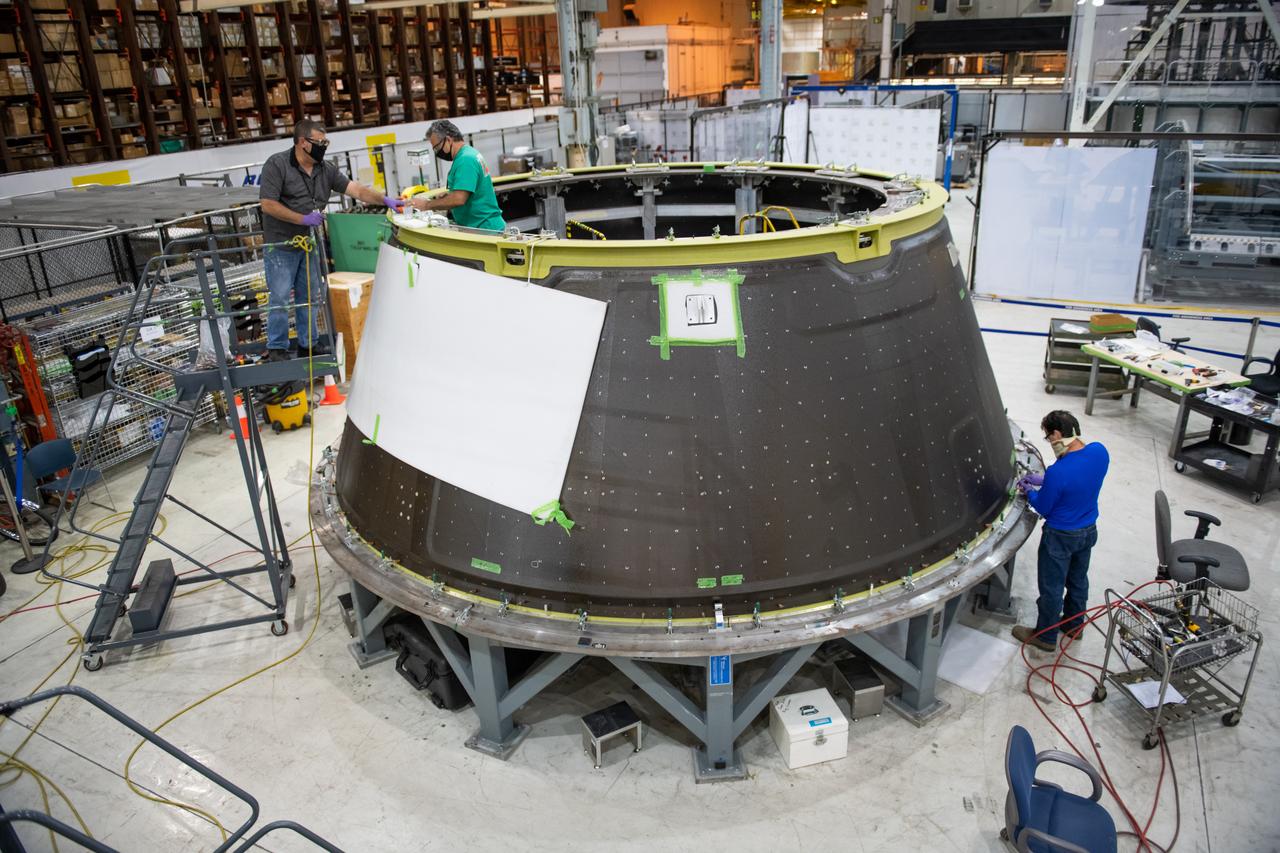 Lockheed Martin technicians perform drilling and assembly operations on the Orion spacecraft adapter cone forward and aft rings.