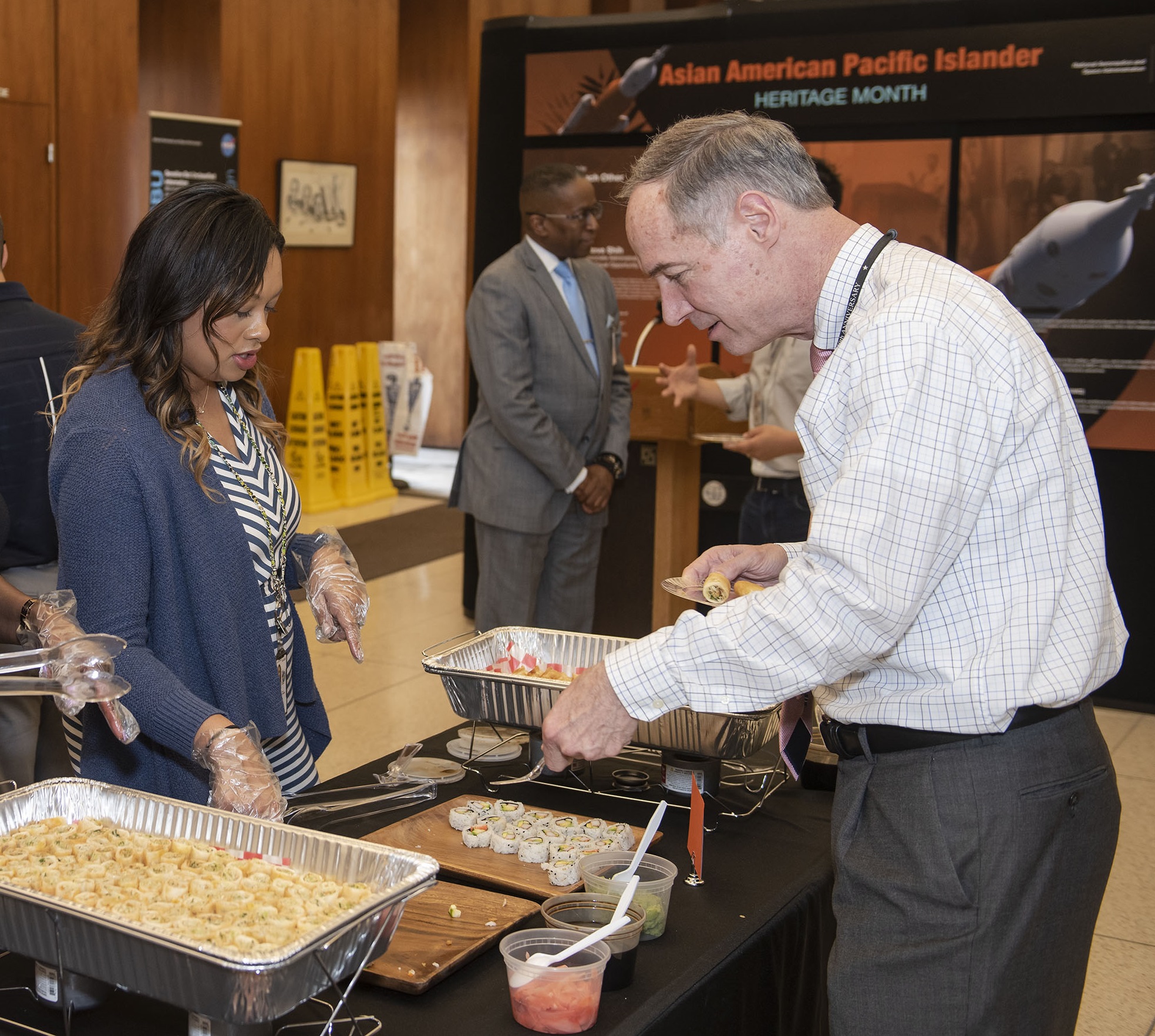 Jennifer Patton, left, serves traditional Thai cuisine to James Frees, deputy chief counsel in the Office of the Chief Counsel.