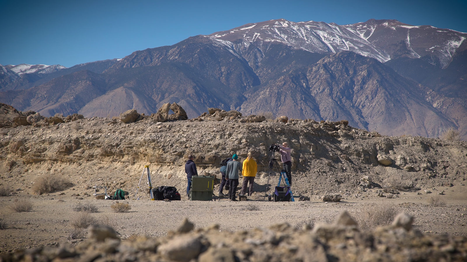A field team sets up equipment in a dry lakebed in the Nevada