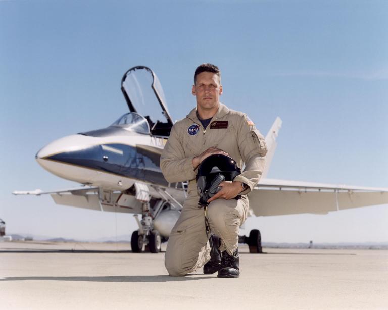 Man posed in front of aircraft.
