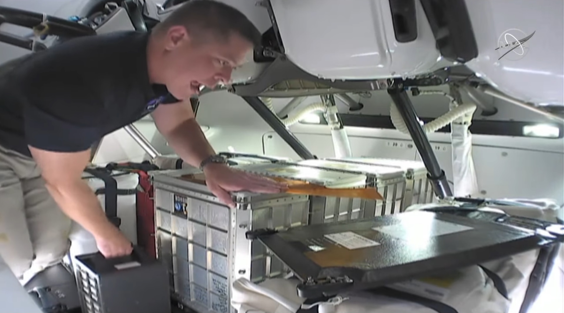 Astronaut Bob Behnken places his left hand one of four student-built HUNCH lockers.