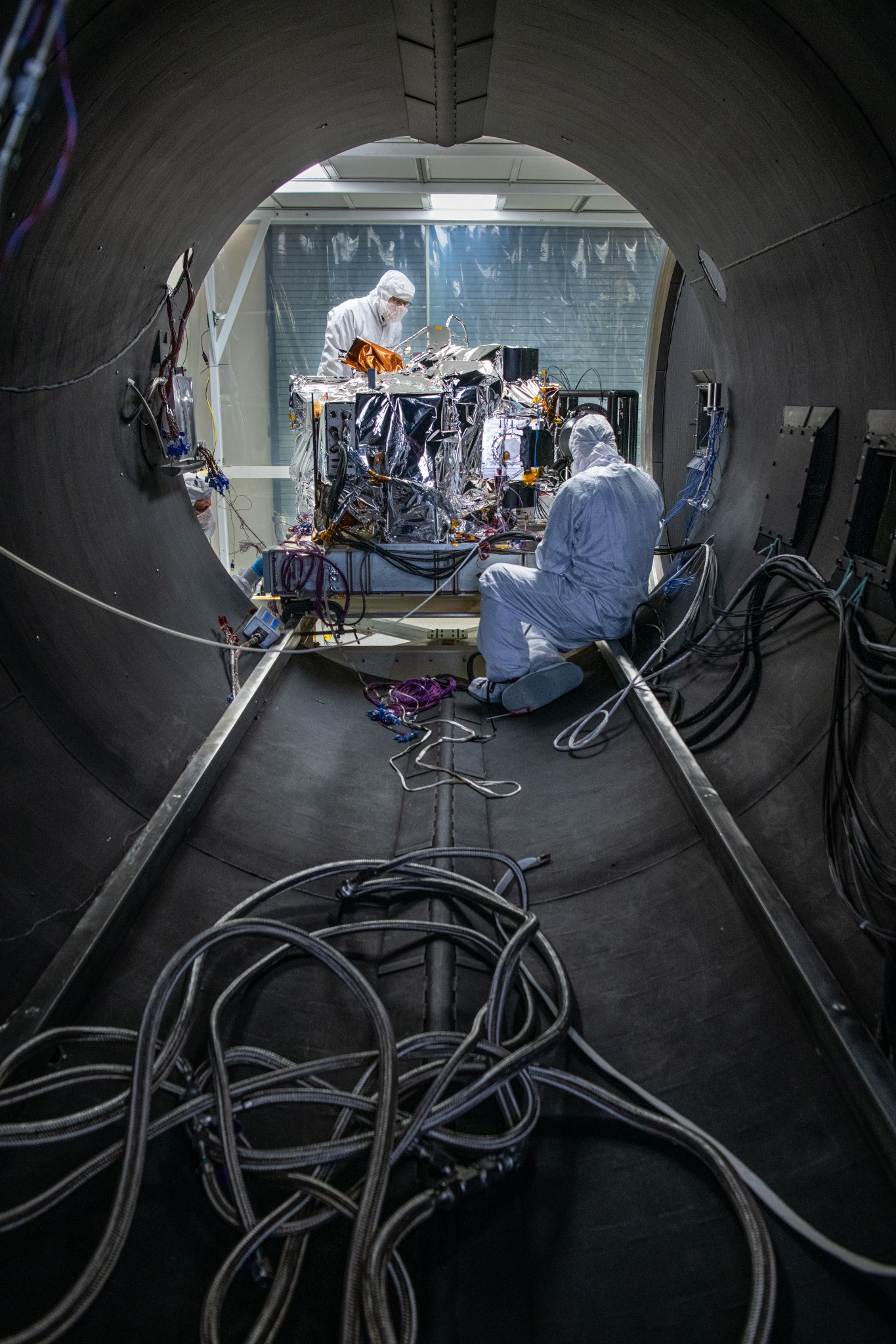 Scientists working in a round testing chamber