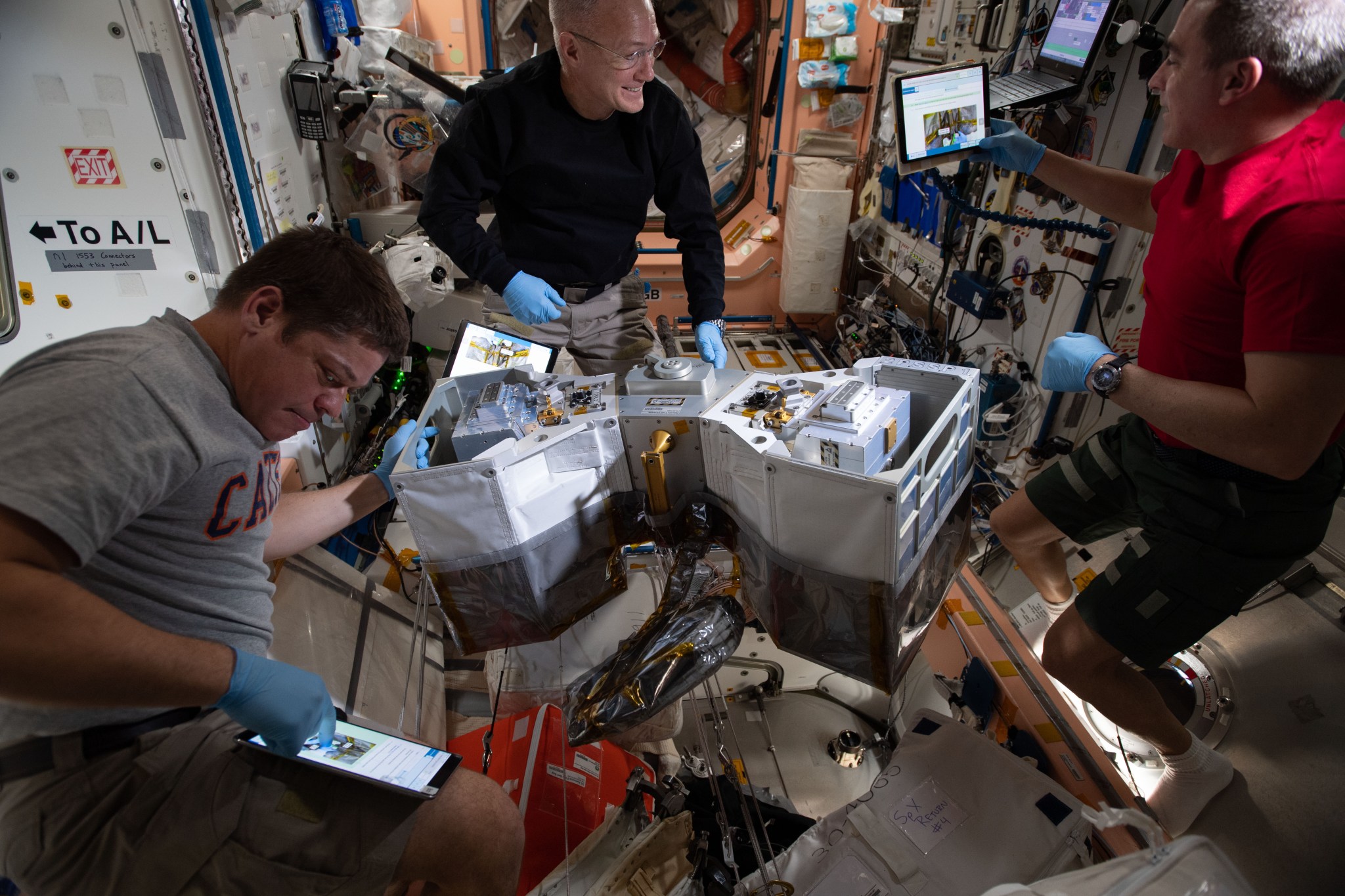 astronauts Bob Behnken, Doug Hurley, and Chris Cassidy preps the RiTS for installation