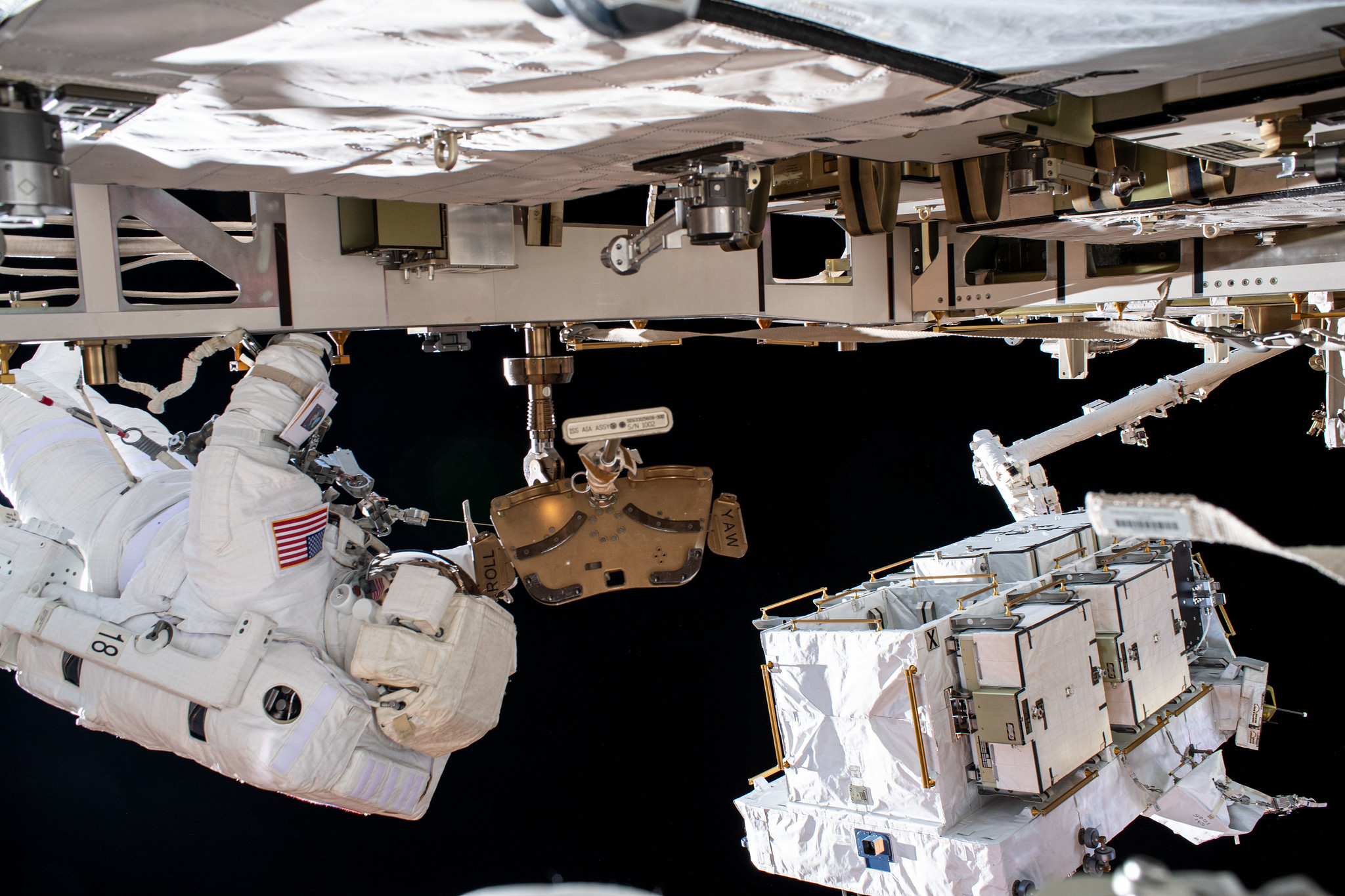 NASA astronaut Bob Behnken (at left) is pictured during a spacewalk to swap batteries and upgrade power systems on the ISS