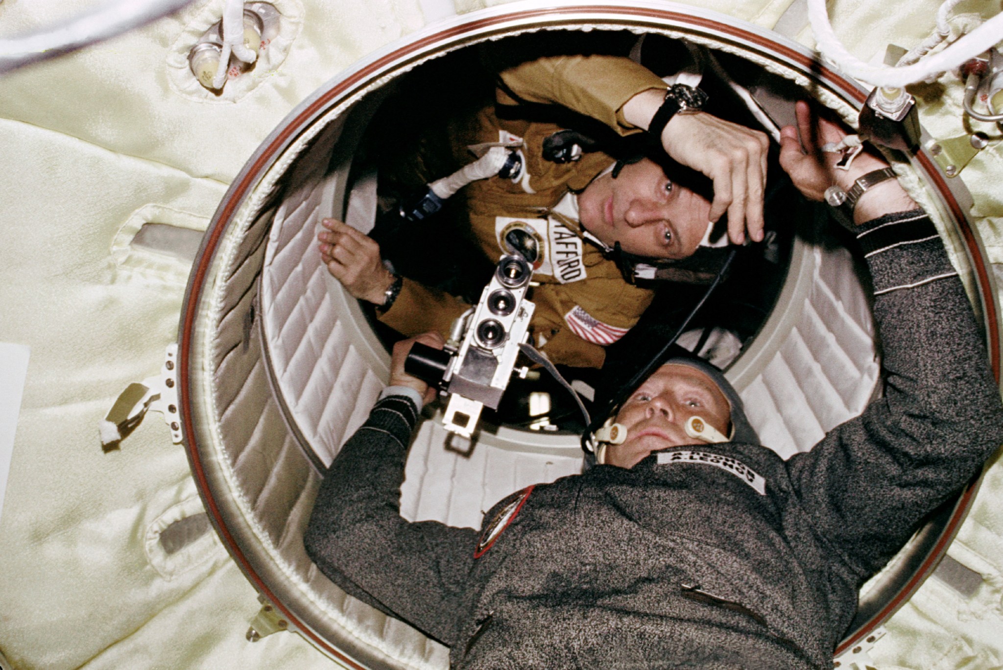 U.S. astronaut and cosmonaut meet in the hatchway leading from Apollo to the Soyuz orbital module.