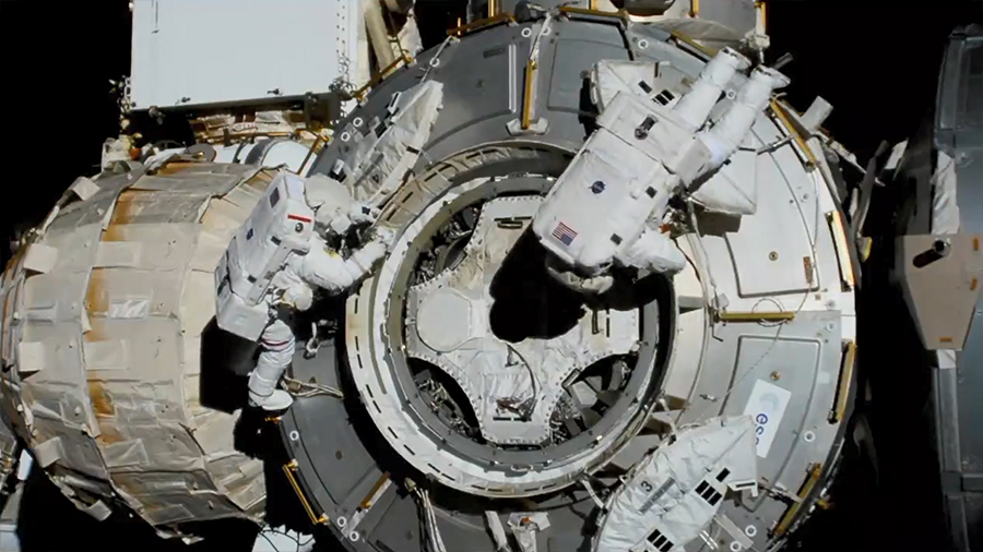 Bob Behnken, left with red stripe on shoulder, and Chris Cassidy work on the International Space Station during a spacewalk.