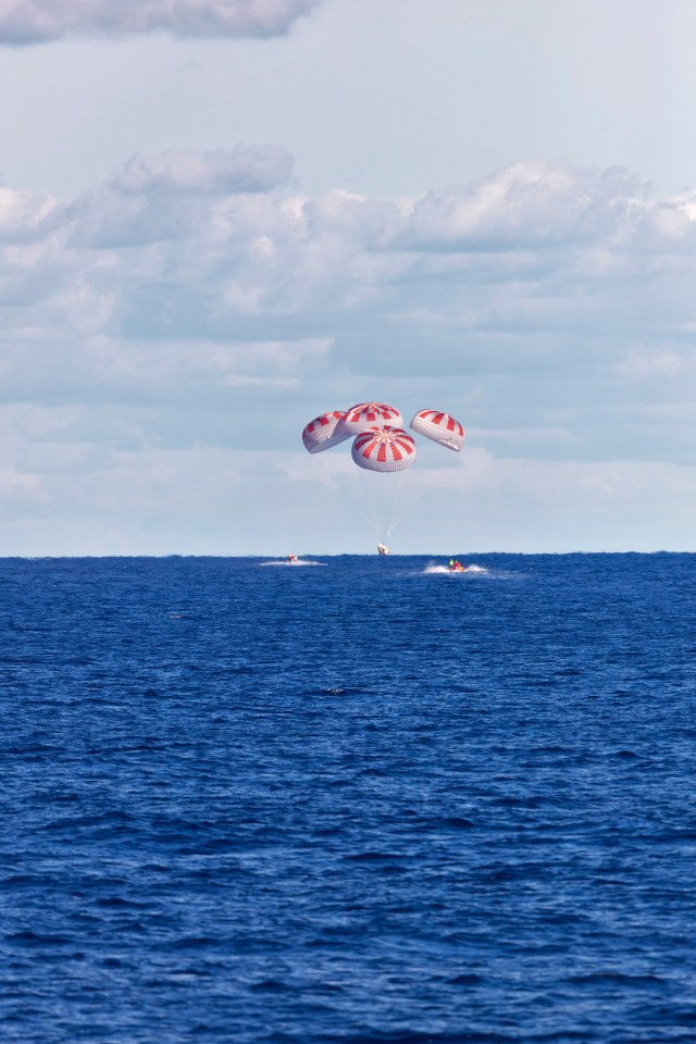 SpaceX’s Crew Dragon is guided by four parachutes as it splashes down in the Atlantic Ocean on March 8, 2019