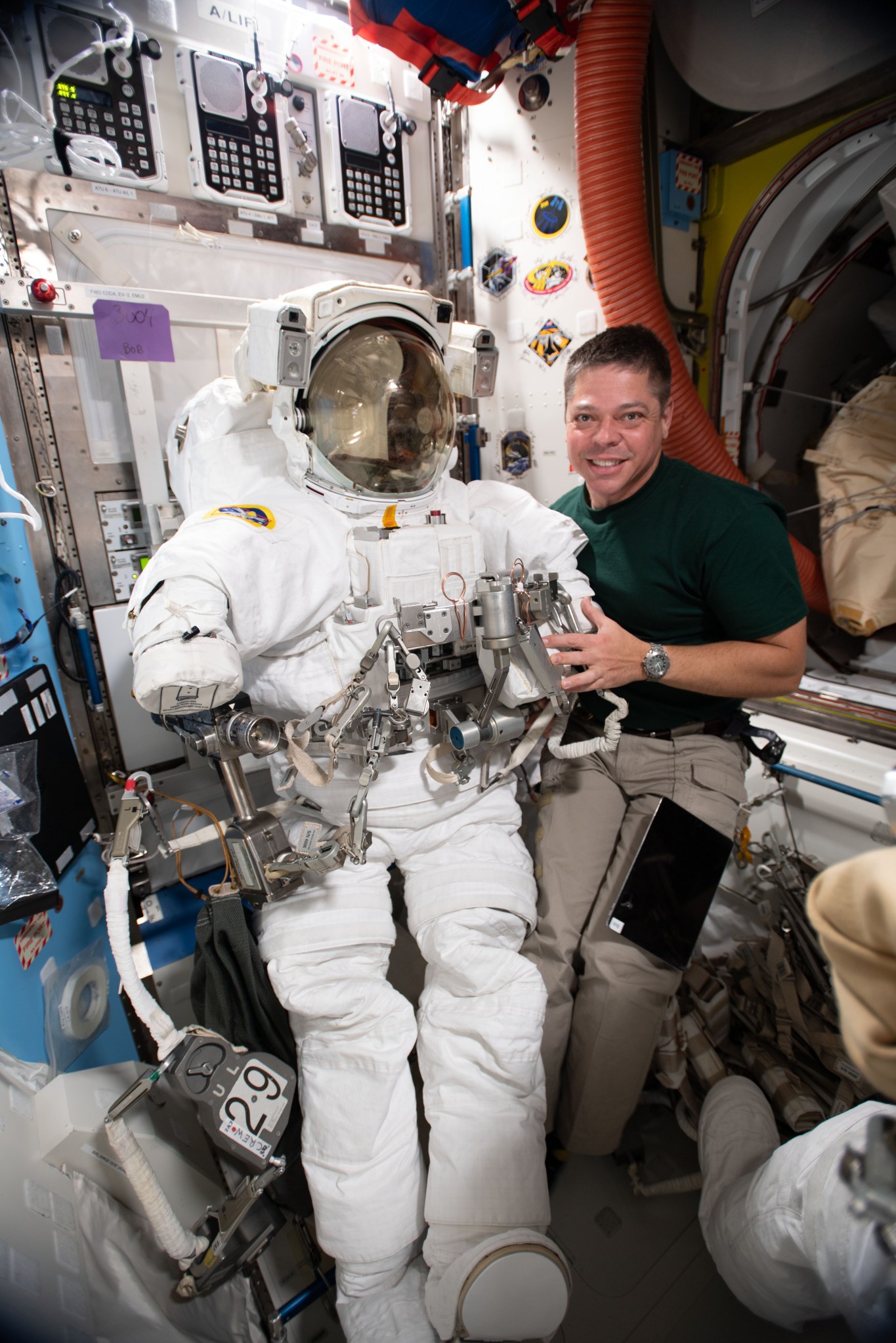 Expedition 63 flight engineer Bob Behnken poses with an Extravehicular Mobility Unit in the Airlock.
