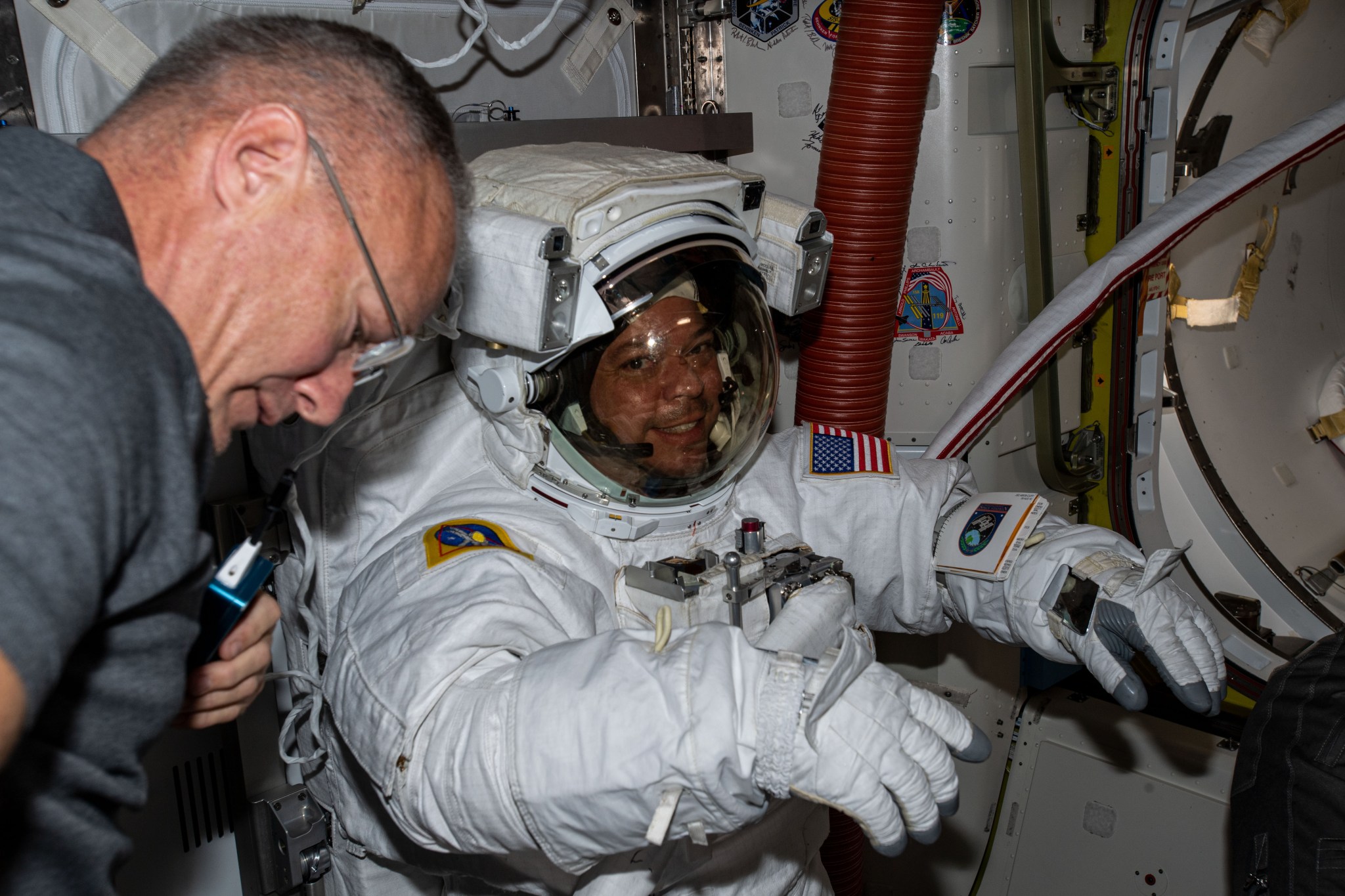 NASA astronaut Doug Hurley prepares NASA astronaut Bob Behnken for Extravehicular Activity 65 in the Airlock