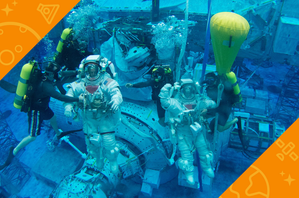 Astronauts performing mock ISS maintenance underwater in the neutral buoyancy lab