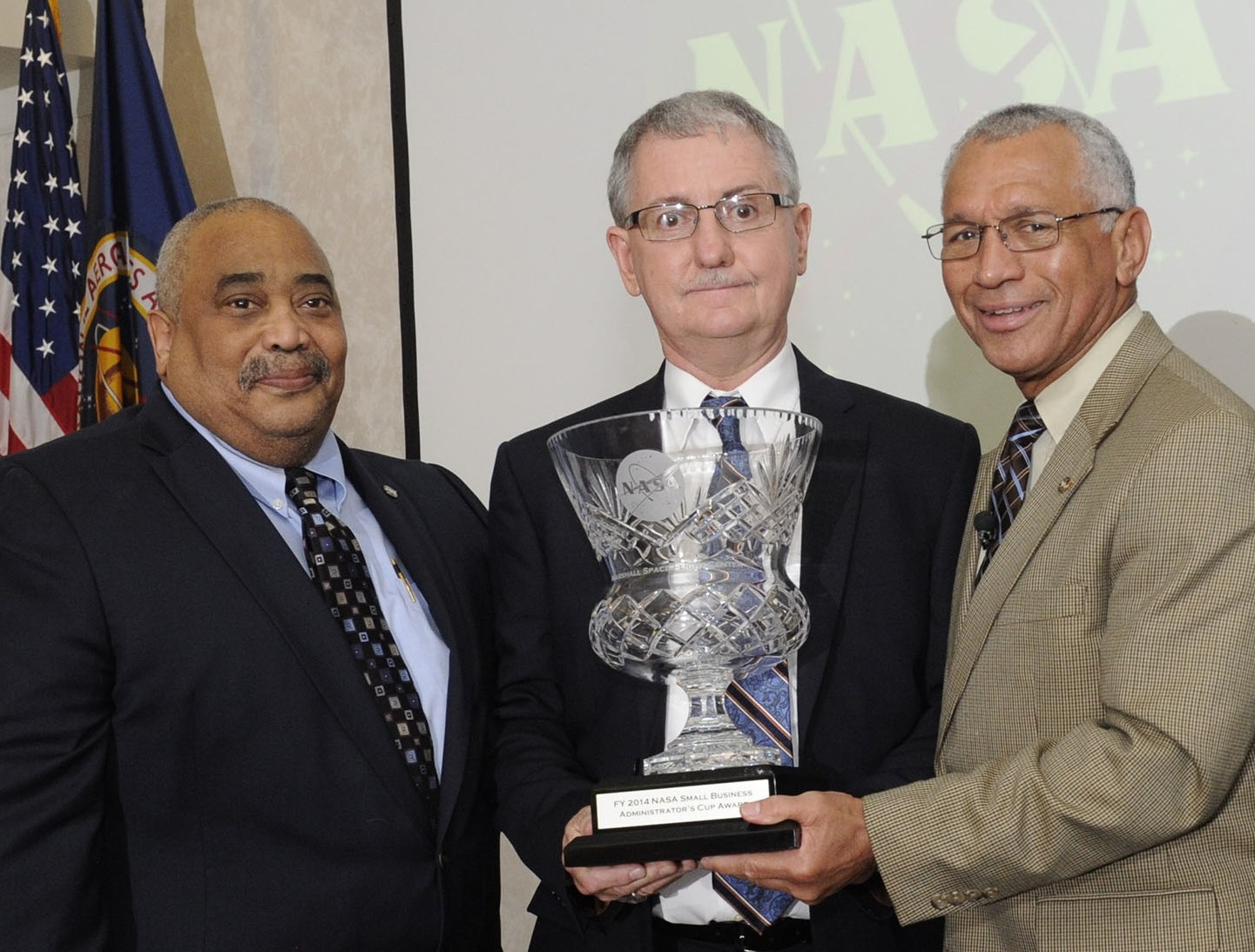 David Brock, center, accepts the NASA Small Business Administrator’s Cup in 2015 from former NASA Administrator Charles Bolden.