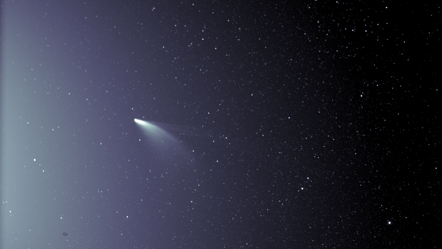 Comet NEOWISE is seen against a background of stars with two bright, distinct tails