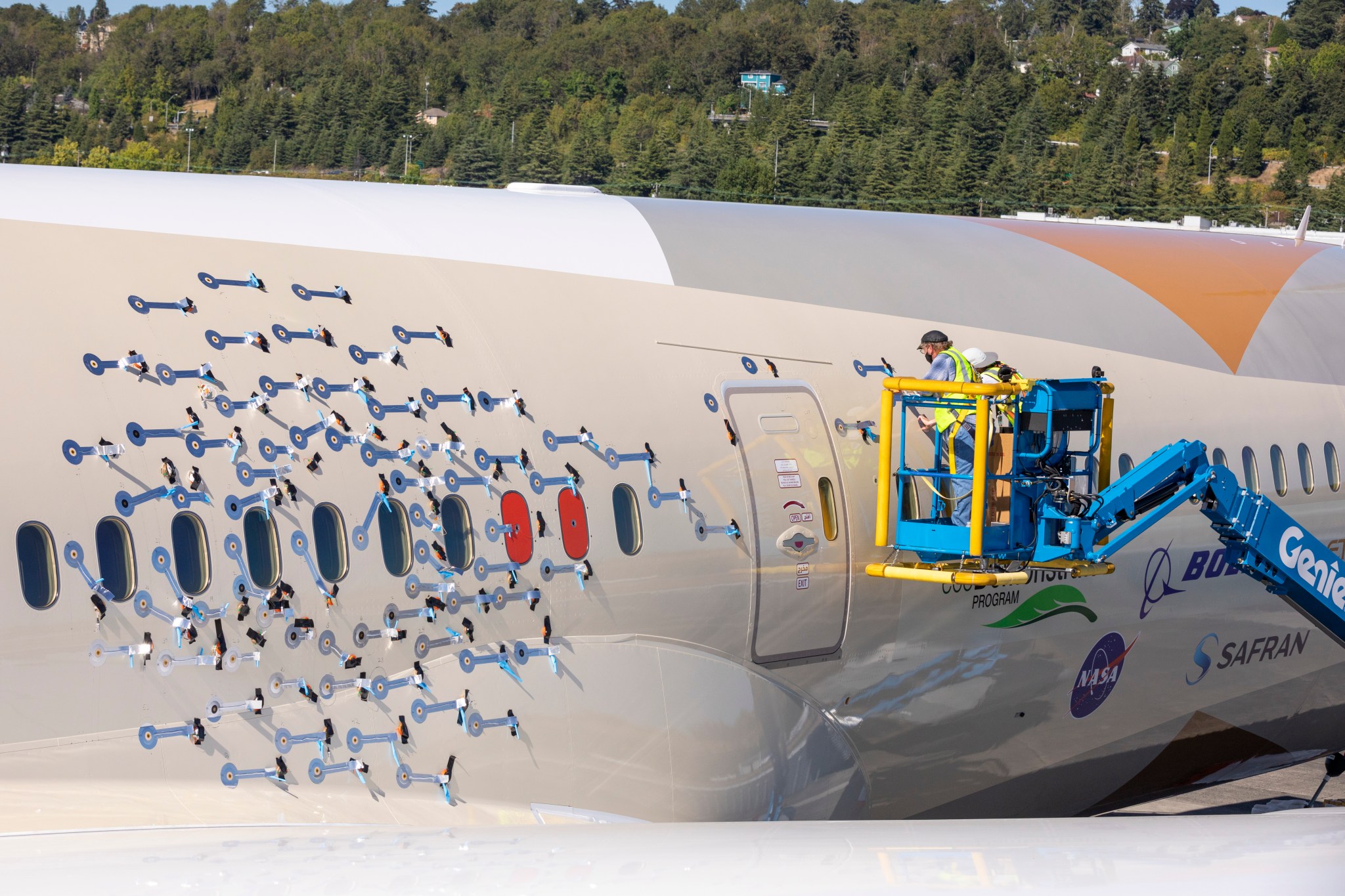 A technician completes work to install 214 microphones to the exterior of a 787-10 Dreamliner.