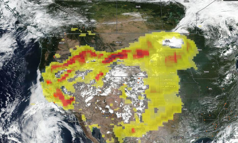 Satellite image of California and surrounding areas. A yellow and red pixelated cloud moves over the land. Clouds and smoke are scattered across the image. 
