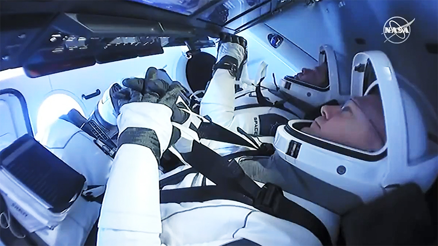 Astronauts (front to back) Doug Hurley and Bob Behnken are suited up inside the SpaceX Crew Dragon preparing for splashdown.