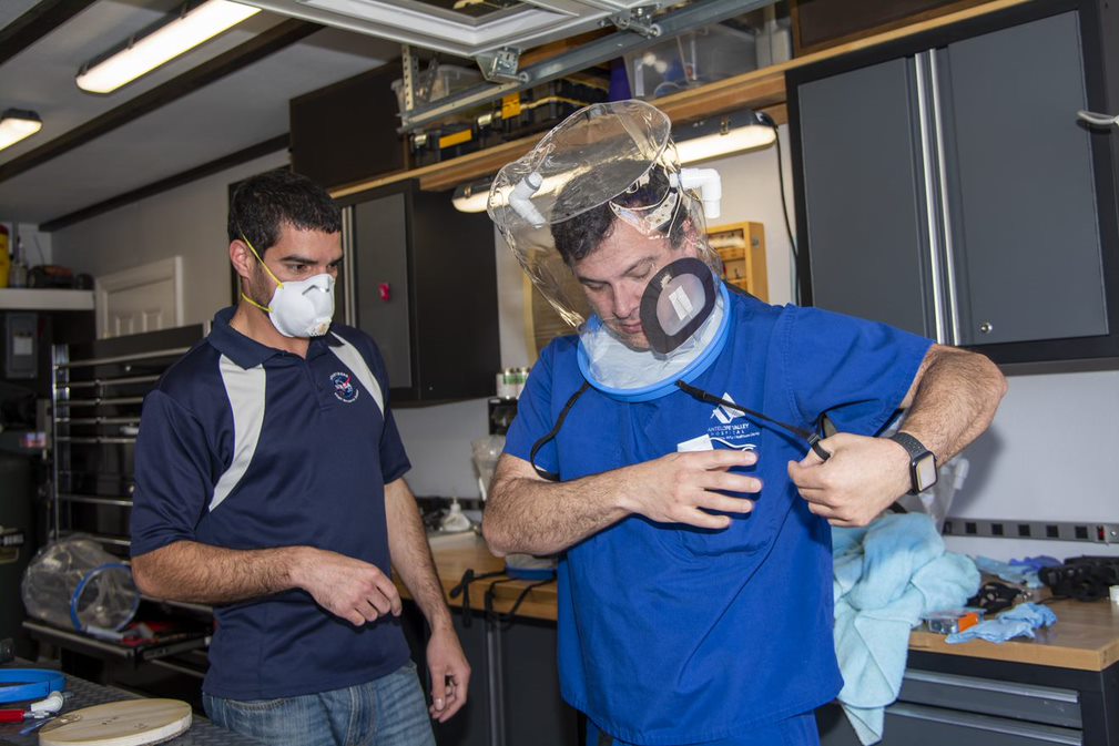 Engineers testing oxygen helmets.