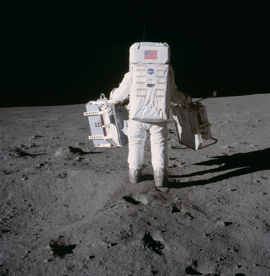Apollo 11 astronaut Buzz Aldrin carries two components