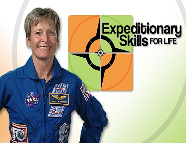 Astronaut Peggy Whitson stands next to the Expeditionary Skills for Life logo