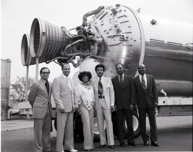 Actress who played Lieutenant Uhura in Star Trek is pictured with five men in front of a propulsion rocket.