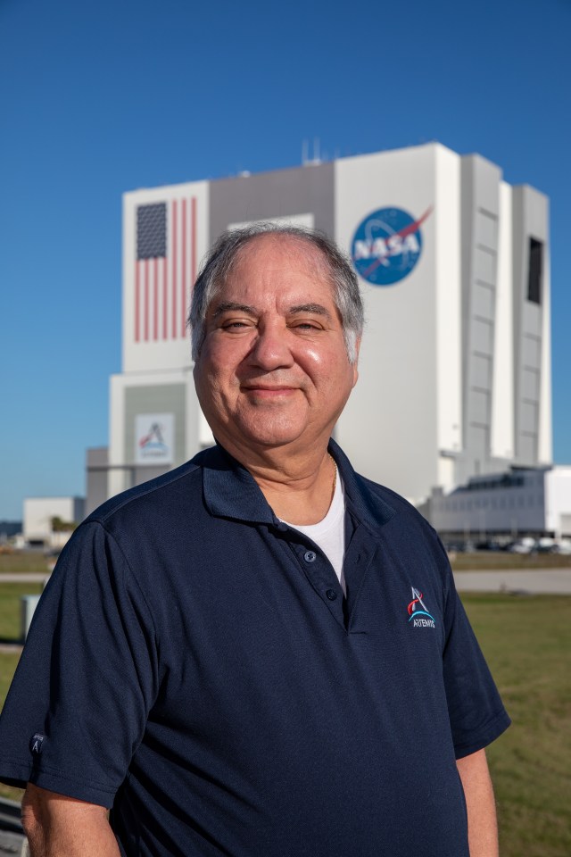 Kennedy Space Center's Jose Perez Morales is photographed with the Vehicle Assembly Building in the background.