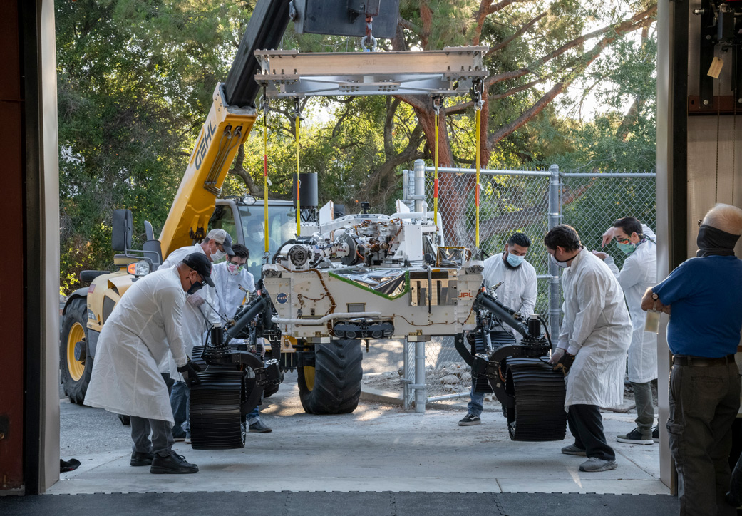 Technicians move an engineering version of the Perseverance Mars rover