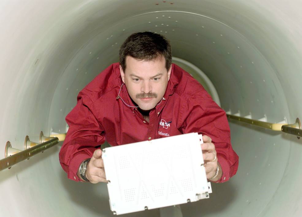 sts_106_altman_carrying_battery_through_tunnel