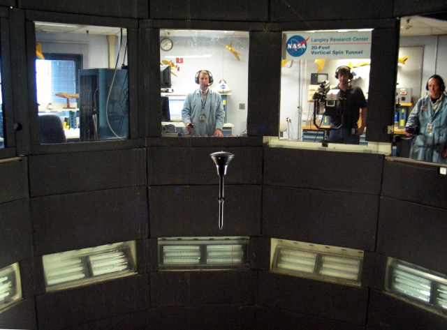 Technicians observing a test inside the wind tunnel.