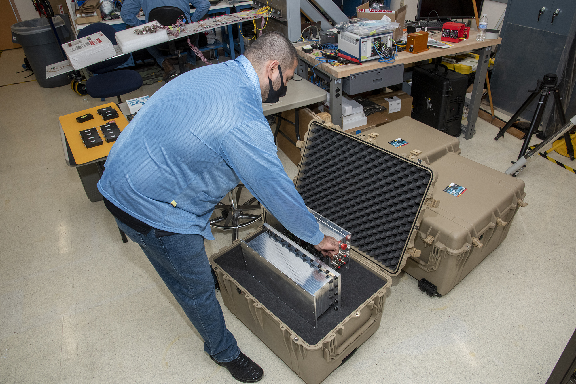 NASA research engineer Jonathan Lopez secures a Compact Fiber Optic Sensing System unit.