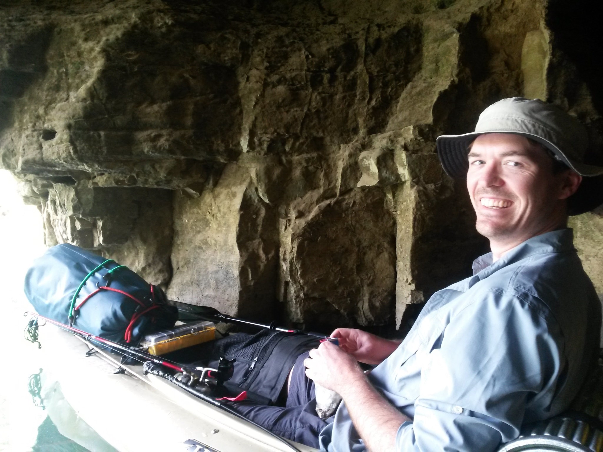 smiling man in canoe in cave