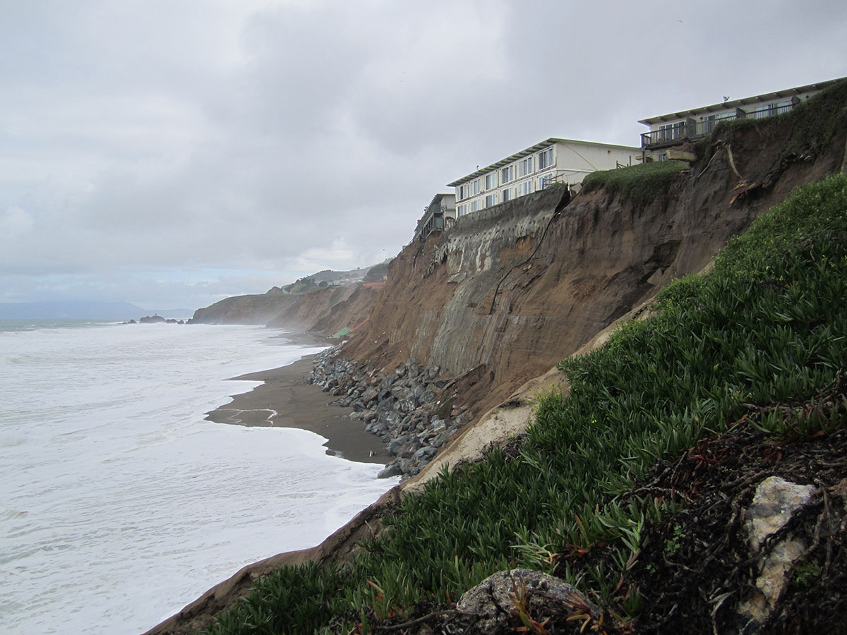 Photo of eroding 60-foot cliff with houses on top on the U.S. West Coast