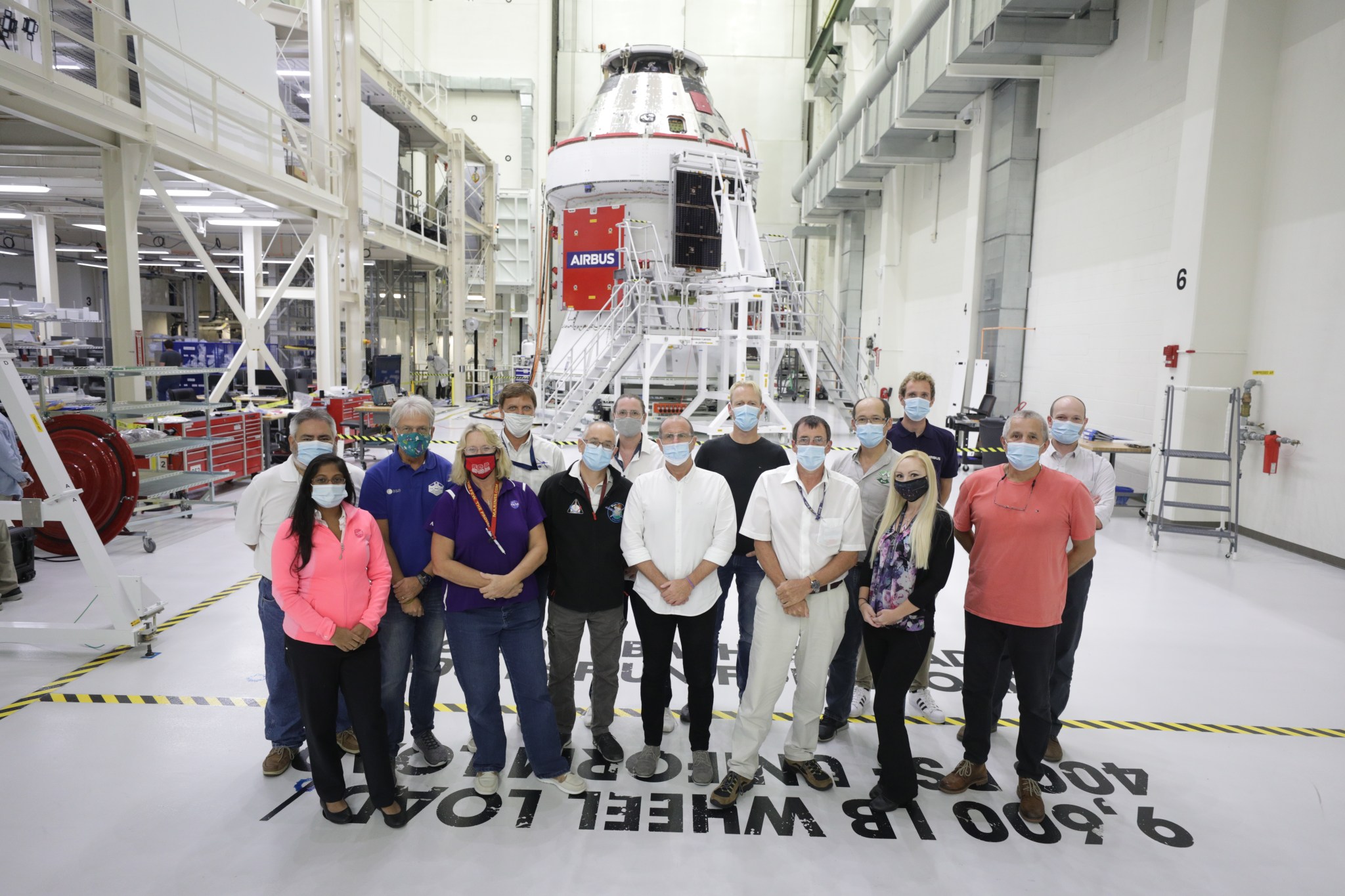 The team that installed Orion's solar array wings for Artemis I poses for a photo.
