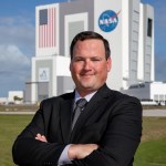 A photo of Kennedy Space Center's Wes Mosedale with the Vehicle Assembly Building in the background.