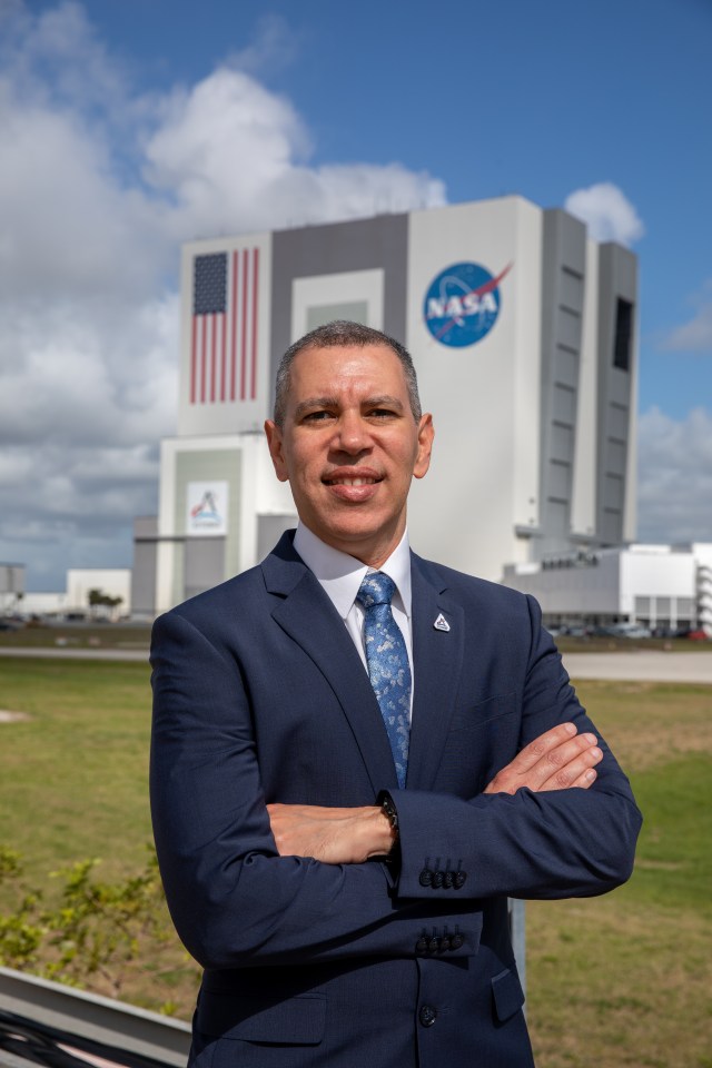 A photo of Kennedy Space Center's Danny Zeno with the Vehicle Assembly Building in the background.