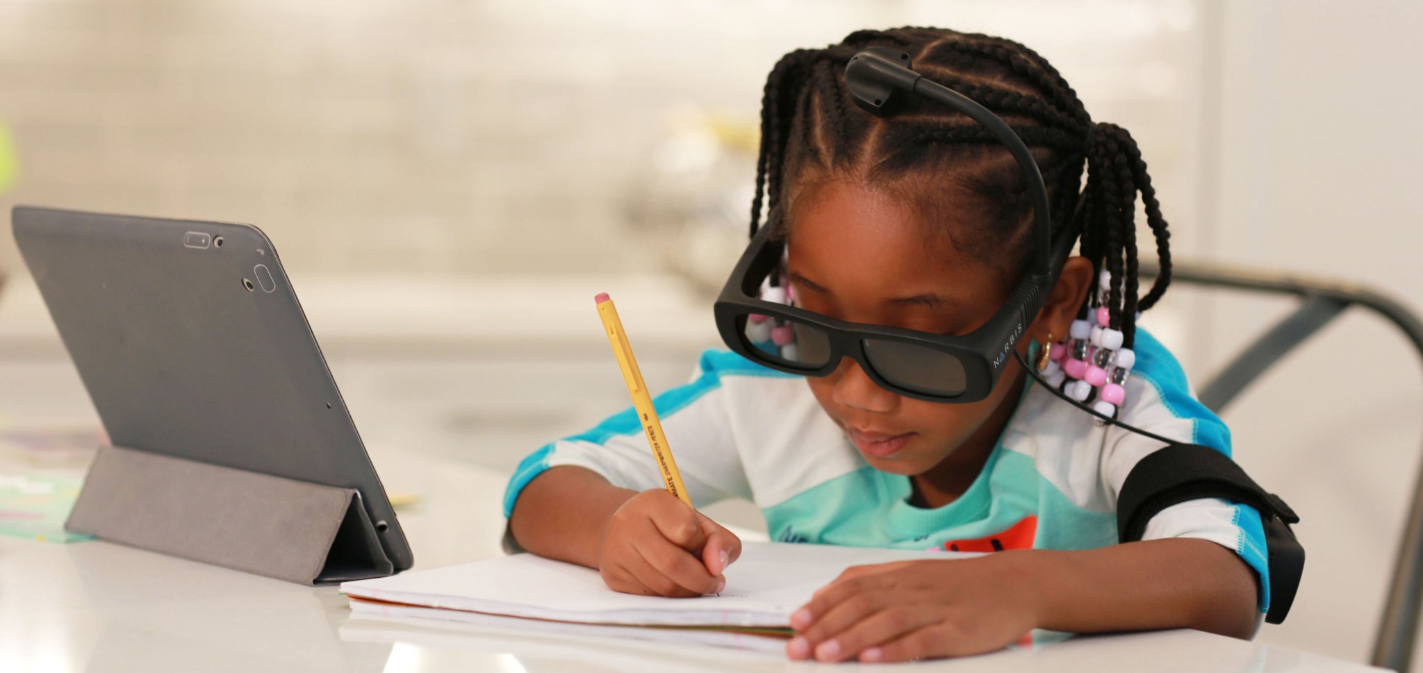 student wearing glasses working next to a computer