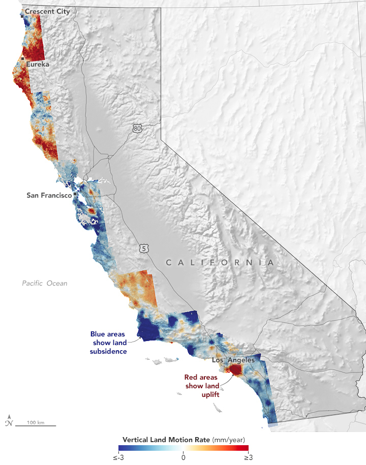 Map of California showing regions of land subsidence and uplift along the coast. The state appears gray, with mountains visible in lighter areas and valleys looking darker. Areas that are sinking appear in shades of blue, and mostly include the central and lower parts of the coast. Areas that are rising appear in shades of red, and mostly appear in the northern part of the state with hotspots in the center and near Lost Angeles. Labels show subsidence (blue / sinking) and uplift (red / rising) and also highlight Los Angeles, San Francisco, and other cities in the north.