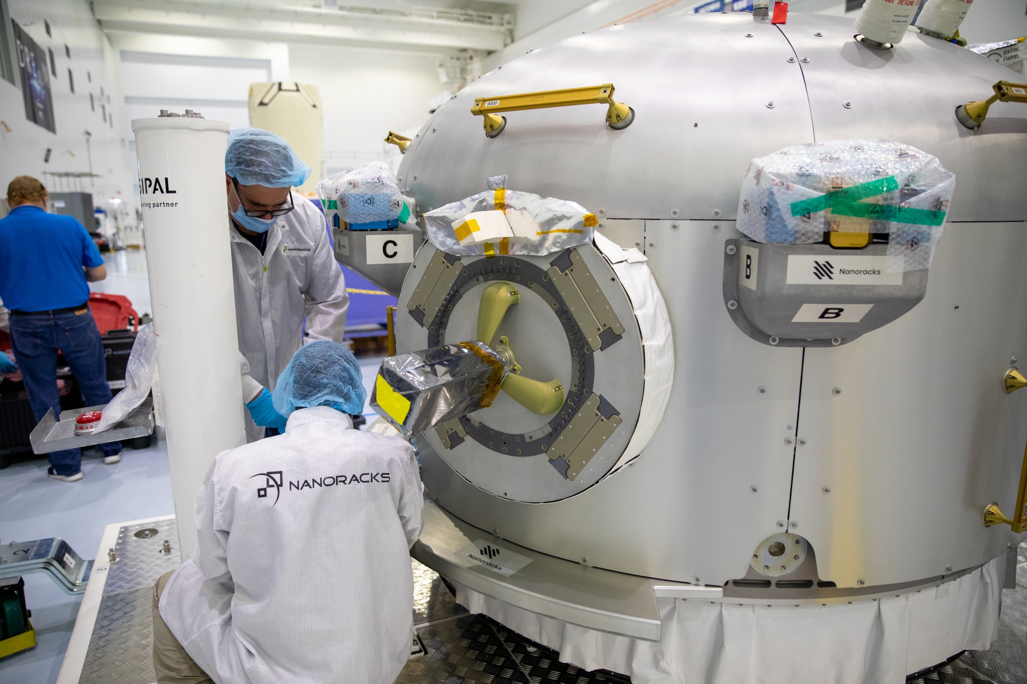 Technicians working on the NanoRacks Airlock inside the Space Station