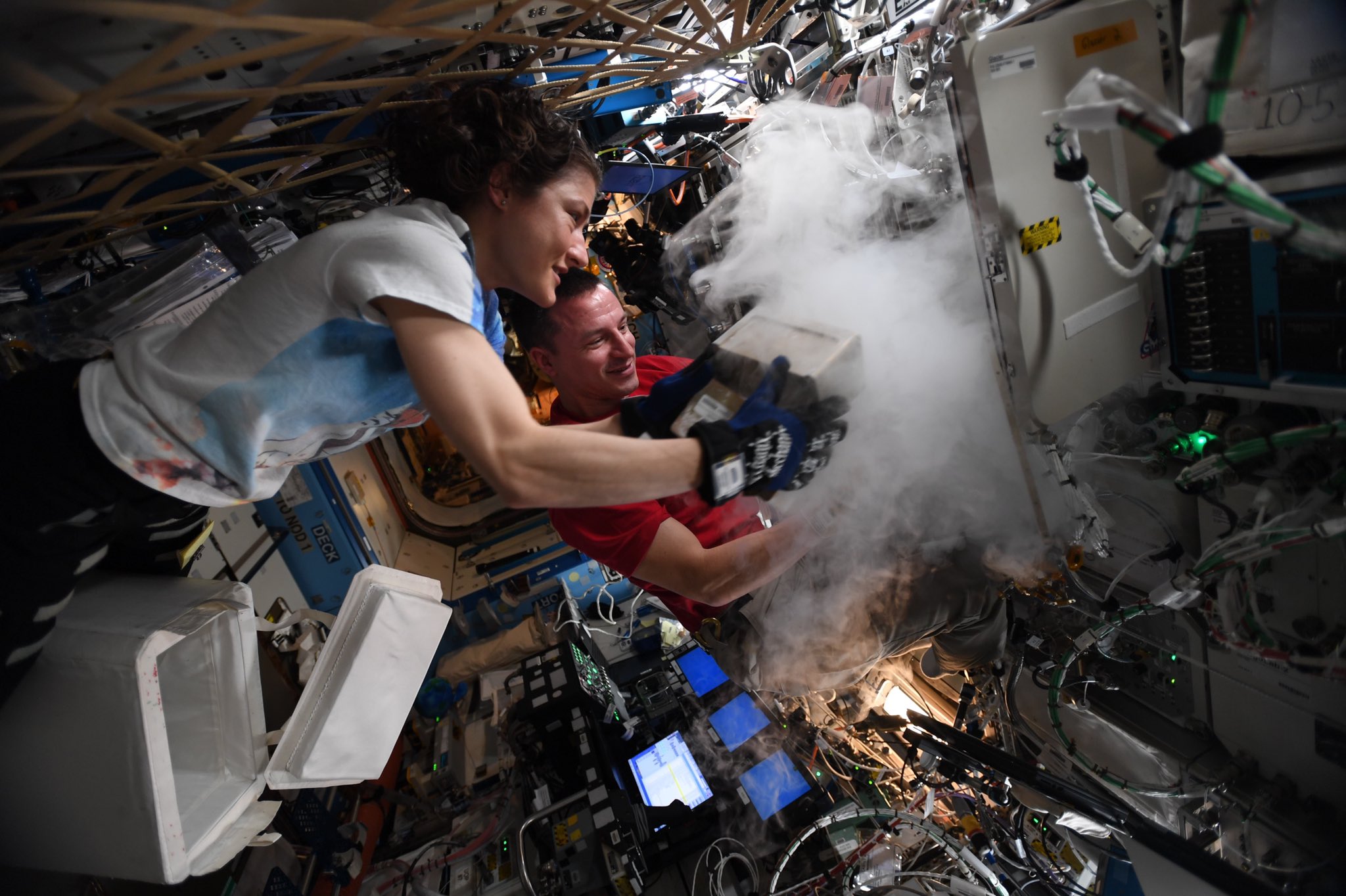 Two astronauts working on an experiment in space