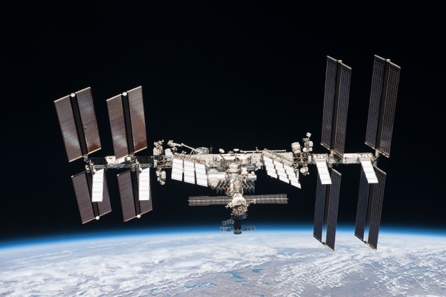A photograph from space of the International Space Station orbiting Earth. The station is a graceful horizontal cylinder with four rectangular solar panels oriented vertically, two on either side of center. In the center are horizontal square panels angled slightly to the right, and science instruments and modules extend out from the center cylinder. The Space Operations Mission Directorate is working to maintain a continuous human presence in low-Earth orbit and preeminent U.S. leadership in space. 