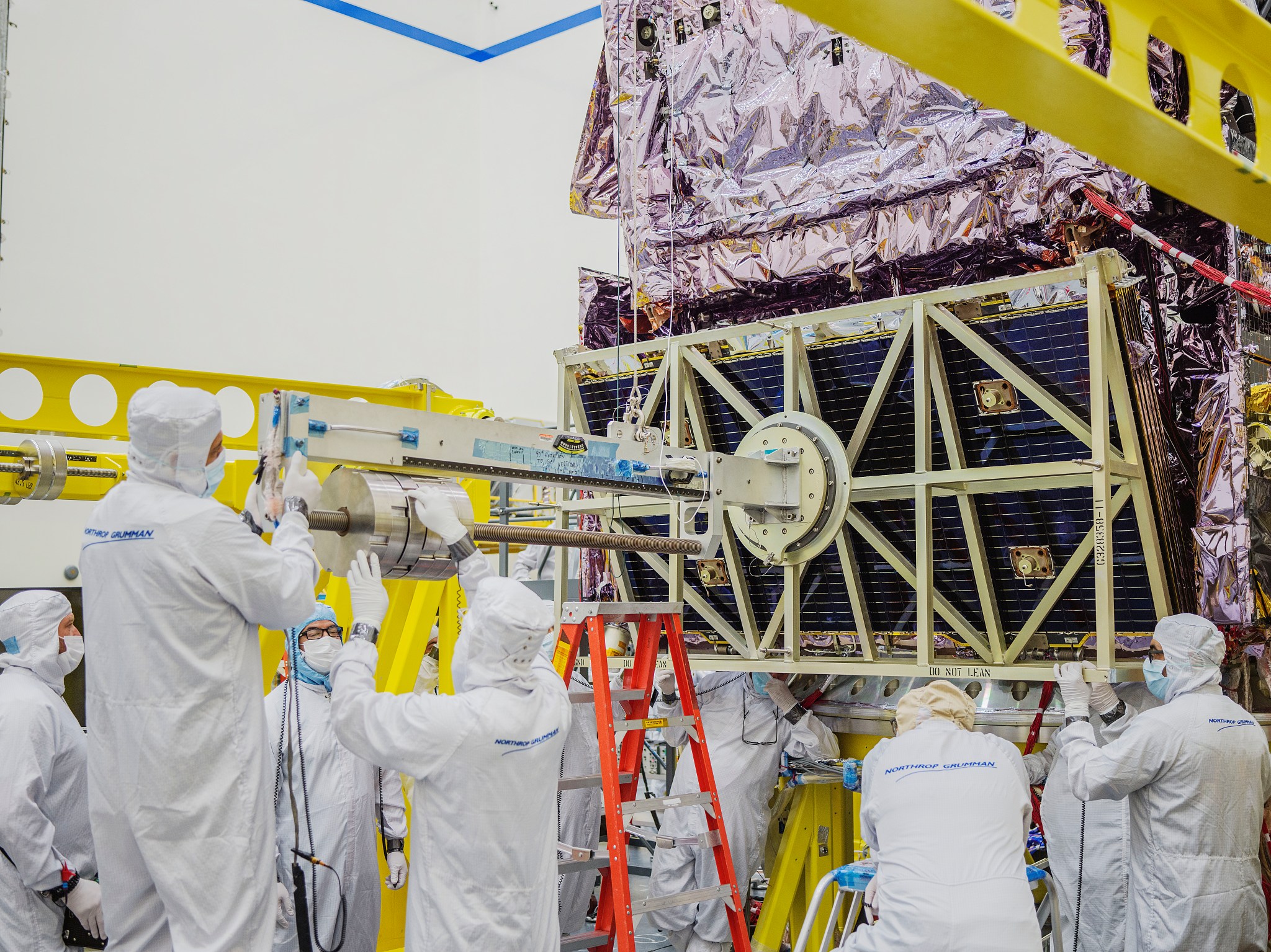 A group of engineers reattach the solar array to the James Webb Space Telescope after it was removed for testing.
