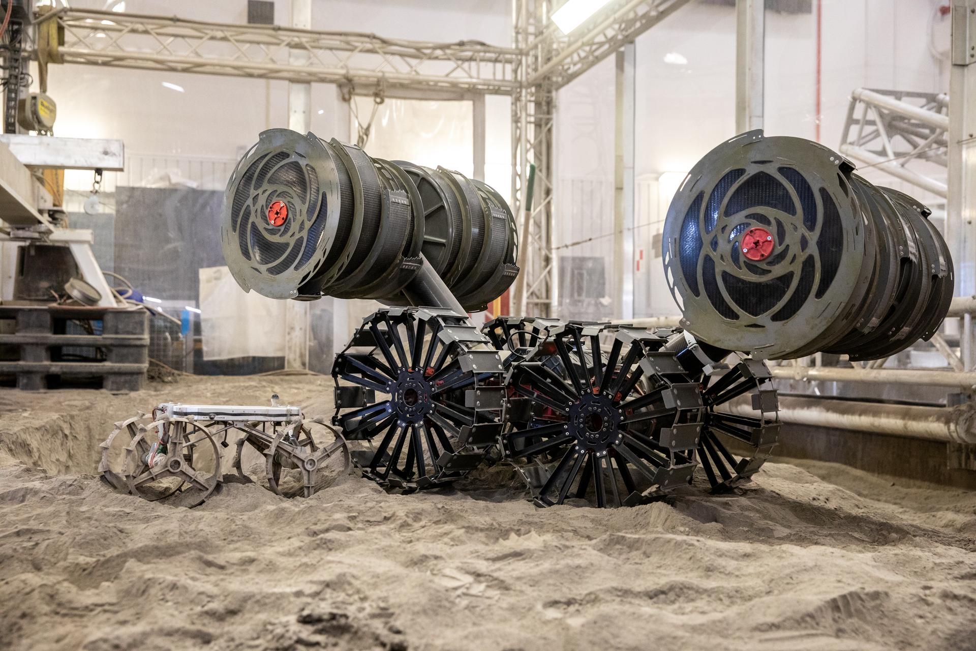 The Astrobotic CubeRover, left, and NASA's RASSOR digging platform are shown in the regolith bin at Kennedy Space Center.